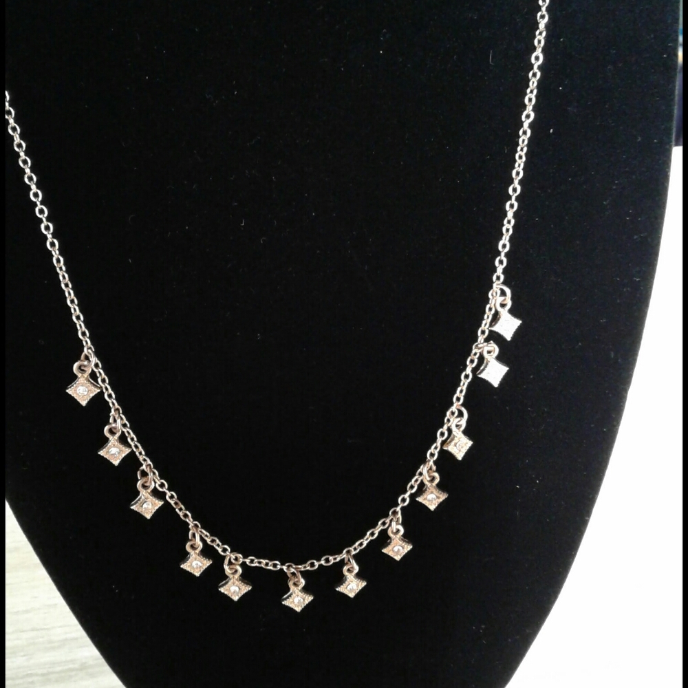 Necklace with clear stones in rose colored metal
